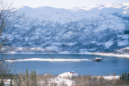 美丽的景观传统挪威木屋站在湖边和远处的山上图片
