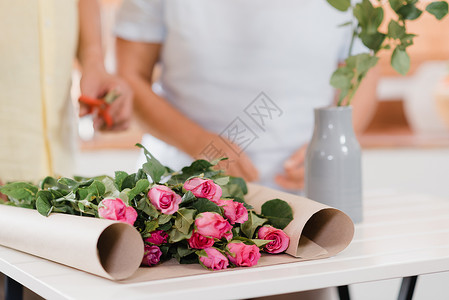 在家的木桌子上做花束的夫妇图片