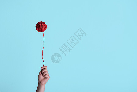 红线球像气一样漂浮女人手握着它奇怪的童年概念最小的风格编织环境图片