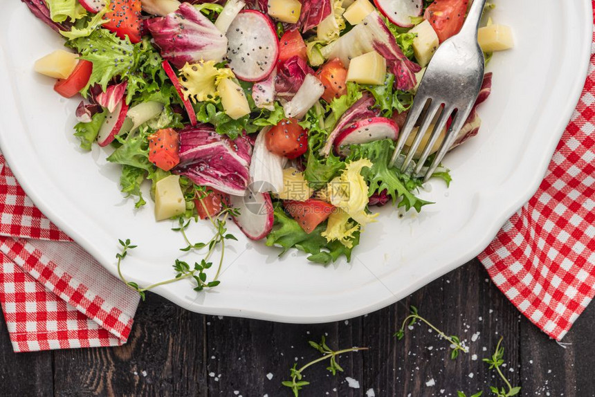 混合绿色萝卜奶酪和番茄的新鲜沙拉放在木制背景的盘子上意大利面食或希腊菜素图片