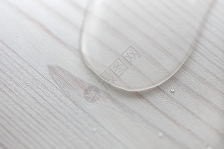 白木板表面的水滴由用蜡遮盖的油层所制成背景图片