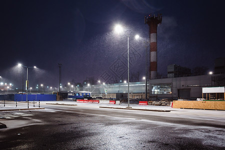 夜间城市郊区的工业街道灯光照亮了从上面降下的雪晚上城市郊区的工业图片