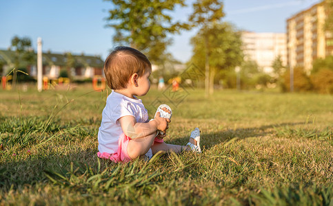 小女孩坐在公园草地上图片
