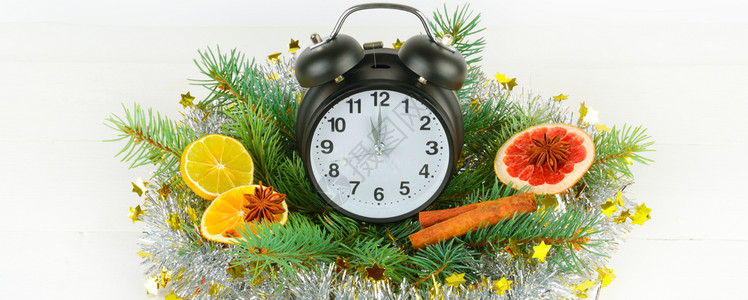 圣诞装饰品手表树枝香料白木本底的橙子片图片