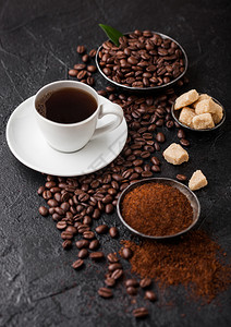 白杯新鲜生有机咖啡豆子和土粉甘蔗糖立方体深底有咖啡树叶图片
