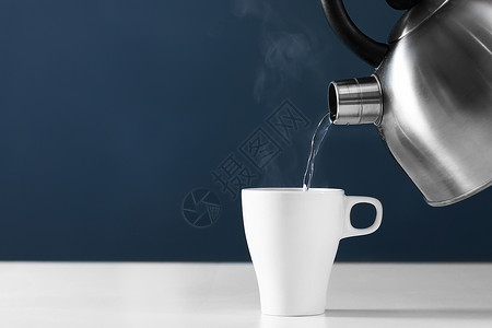 咖啡和水素材将热水倒进黑暗背景的杯子里背景
