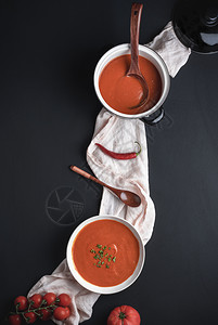 碗盘里有美味的番茄奶油汤土制的用新鲜西红柿和辣椒制成放在黑桌上图片