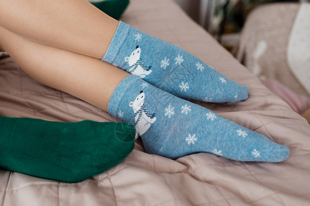 腿长着可爱的蓝袜子白熊和床上的绿袜子图片
