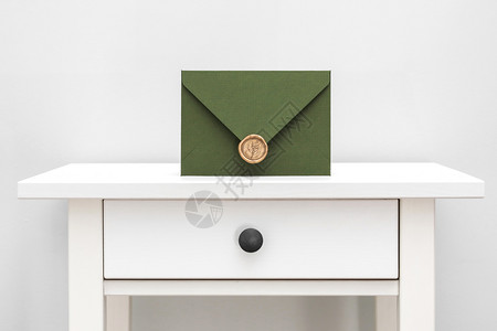 绿色信封带有设计纸板和白色桌子背景的封条绿色信带有设计师纸板和白色背景的封条背景图片