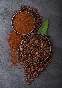 含地粉和黑咖啡树叶的新鲜有机咖啡豆图片
