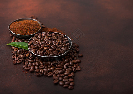 新鲜有机咖啡豆含地粉和棕色咖啡树叶图片