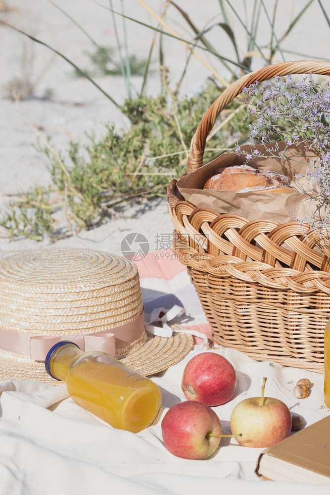 夏天在海边野餐篮子带面包苹果和汁图片
