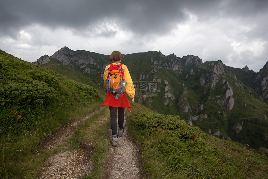 观光女游客正在山上走小路图片