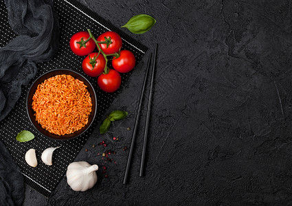 黑盘米碗加西红柿和巴尔大蒜以及黑底的筷子文本空间高清图片