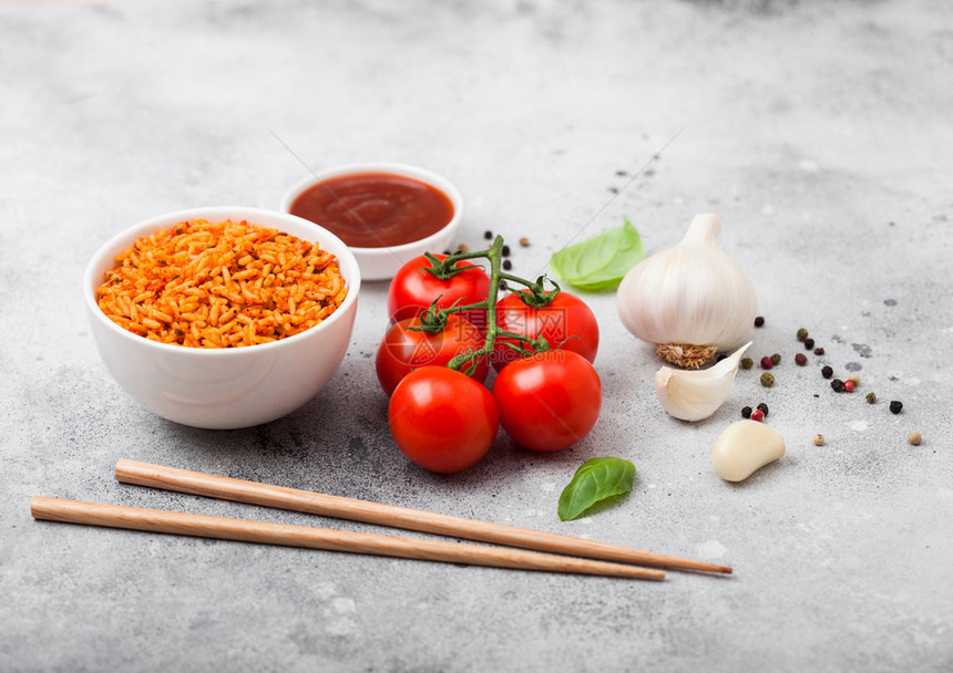 白盘饭碗有西红柿和烤肉大蒜以及浅石本底的筷子图片
