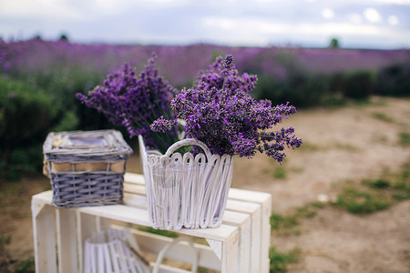 白木凳上羽毛篮子中的衣花束一堆芳香紫花熏衣是设计用于温泉芳香治疗的白菜篮子背景图片