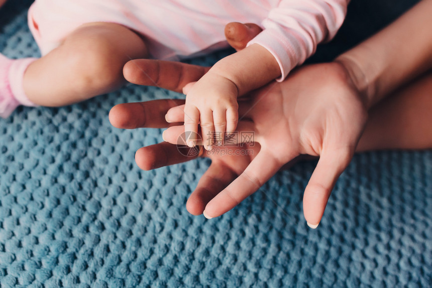 父亲和母手里握着一点婴儿和父母手里握着婴儿和hand孩子和handchilds图片
