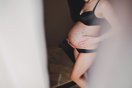 孕妇站着双手抚摸腹部图片
