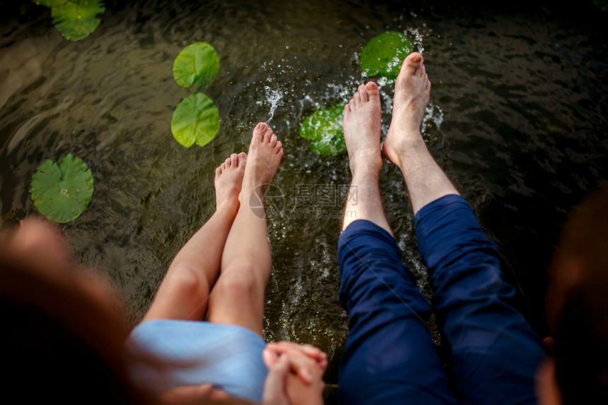 日落时人们在水中玩脚日落时夫妻在水中泼图片