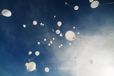 白气球飞向蓝天白云背景图片