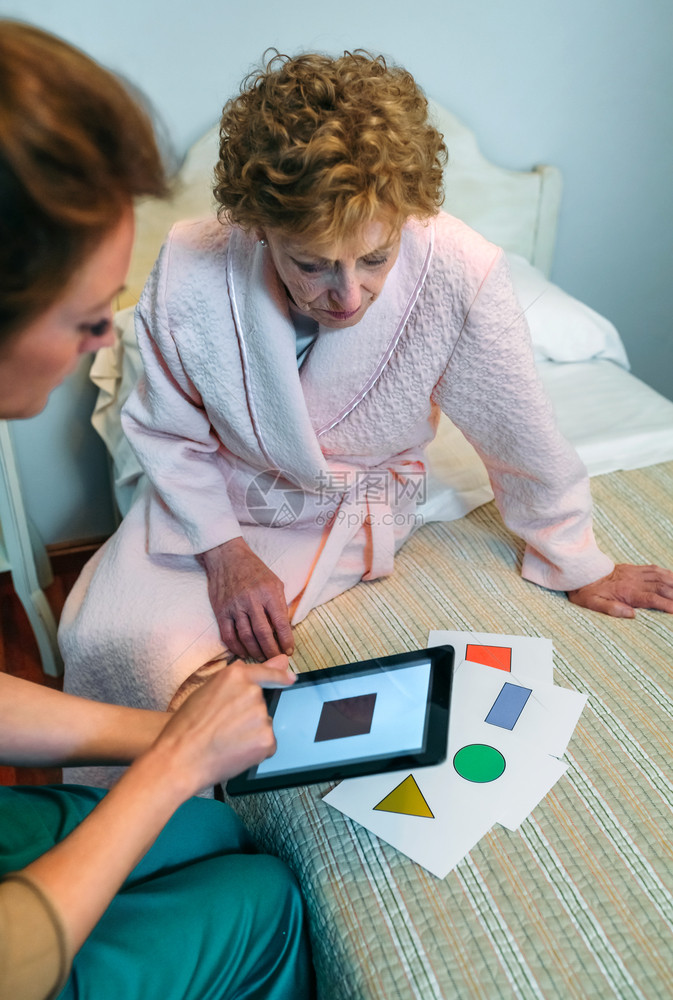 向老年痴呆症女病人展示几何形状游戏的女医生向老年病人展示几何形状的女医生图片