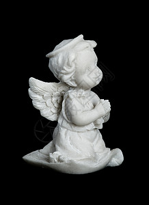 小翅膀一个小男孩的雕塑或像翅膀天使手折在祈祷中孤立黑色背景上背景