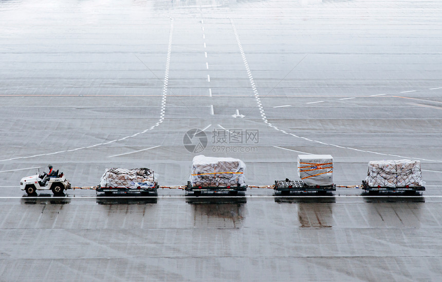 在停机坪国际机场的行李拖车上工作图片