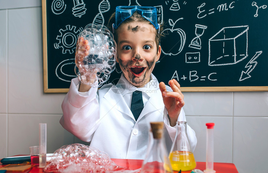 快乐的男孩打扮成化学家在做实验图片