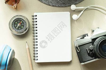 用铅笔照相机罗盘和桌子上的附件打开笔记本的空白页旅行背景概念图片