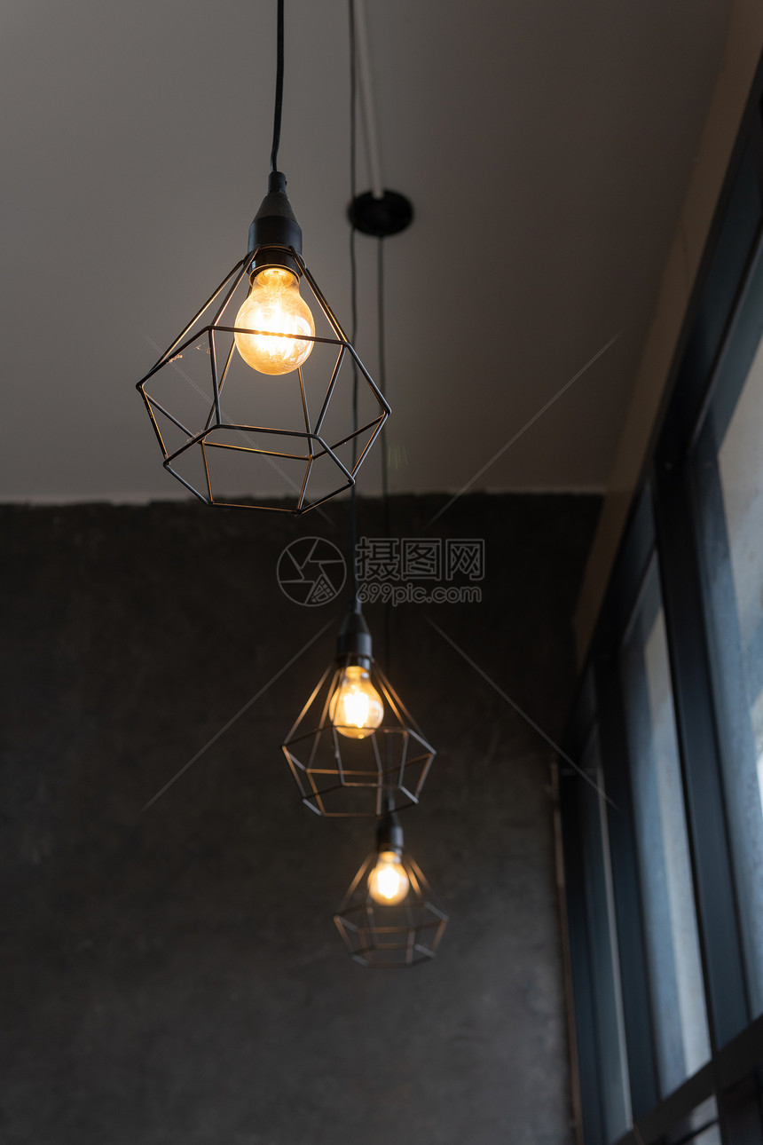 黑钢笼中的灯泡挂在咖啡店的天花板上现代风格的时装灯具和上图片