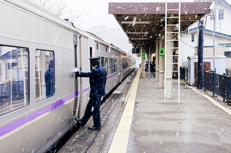 奥努马科恩2018年冬季降雪时在onumaken站台列车停靠火指挥员工作人站在trian门前背景