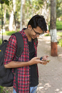 青年男子拿着手机开心的聊天图片