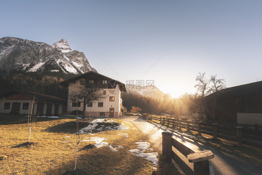 高山村庄和白雪覆盖的阿尔卑斯山脉峰的冬季日落在奥斯特里亚的hrwald山峰在12月的阳光明媚一天图片
