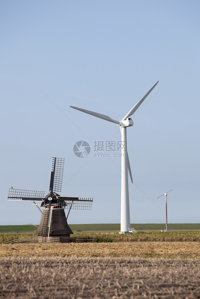 古老风车和现代涡轮机在内地薯田的农业景观中合在一起图片
