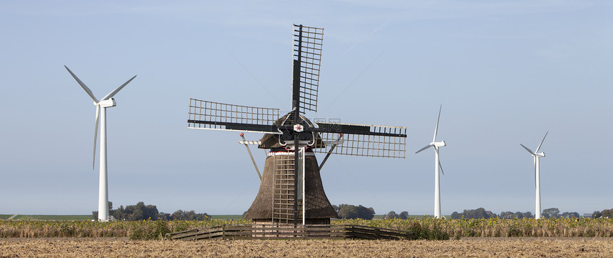古老风车和现代涡轮机在内地薯田的农业景观中合在一起图片