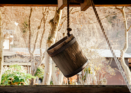挂起来的木桶旧古老的水井木桶上面有挂在洞口的绳子背景