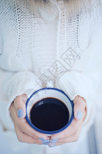 在寒冷的天气背景下手握着热咖啡或茶杯穿着温暖的毛衣编织服图片