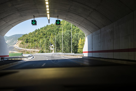 朝向高速公路隧道的标志山路旅行和交通概念从车内看背景