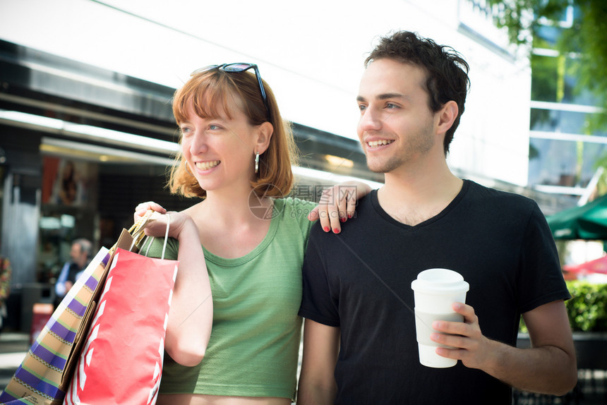 在街上购物后带袋的幸福年轻夫妇图片