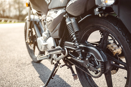 黑色闪亮摩托车的电休克消震器链和磁盘刹车图片