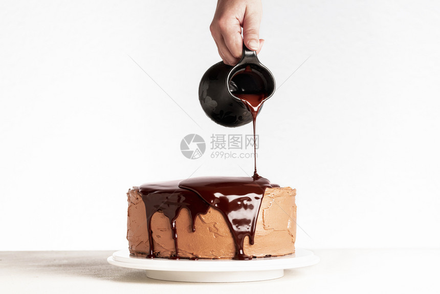 巧克力蛋糕和融化的巧克力女人在蛋糕上倒巧克力土制可层蛋糕生日和滴水巧克力图片