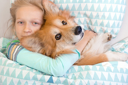 小女孩和狗狗抱着一起睡图片
