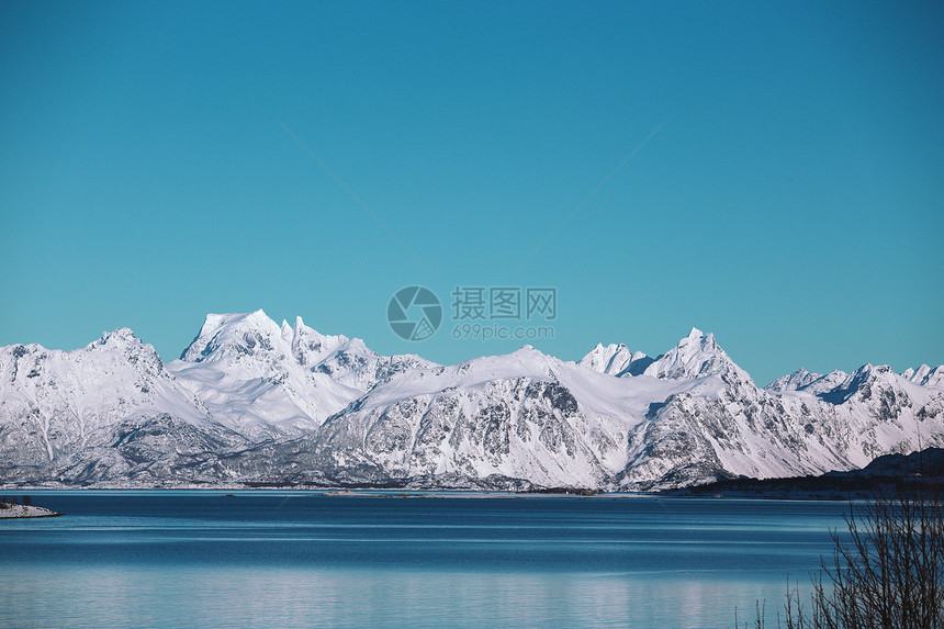 美丽的雪山及其在峡湾的反射渐变蓝的天空图片