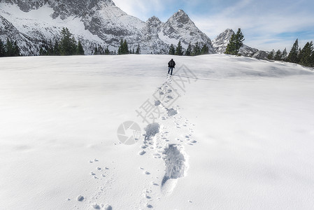 人走过雪层向山峰和林脚步在雪中冬季风景高清图片