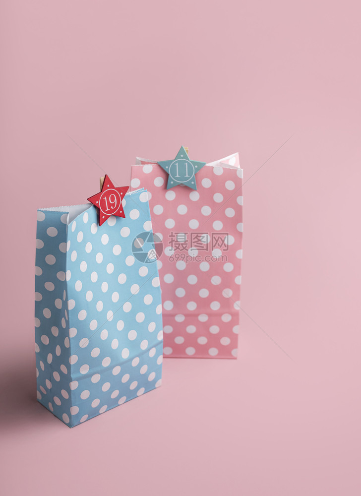 圣诞冒险概念粉红色和蓝礼物袋上面有粉红色背景的数字他和她xma礼物多彩品袋图片