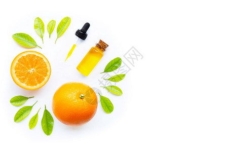 白底带新鲜橙子水果和绿叶的天然柑橘油图片