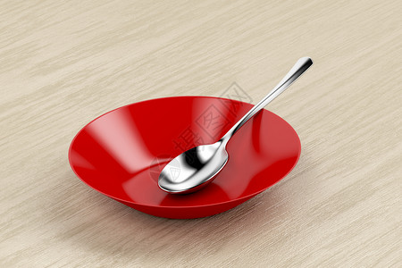 红色空碗和木桌上的银勺子图片