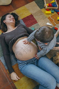 小男孩抚摸怀孕母亲的肚子图片