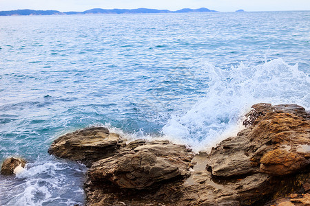 打吊滴清澈的海水冲向岩石和悬崖背景