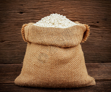米加工以木制背景的布麻袋为米背景